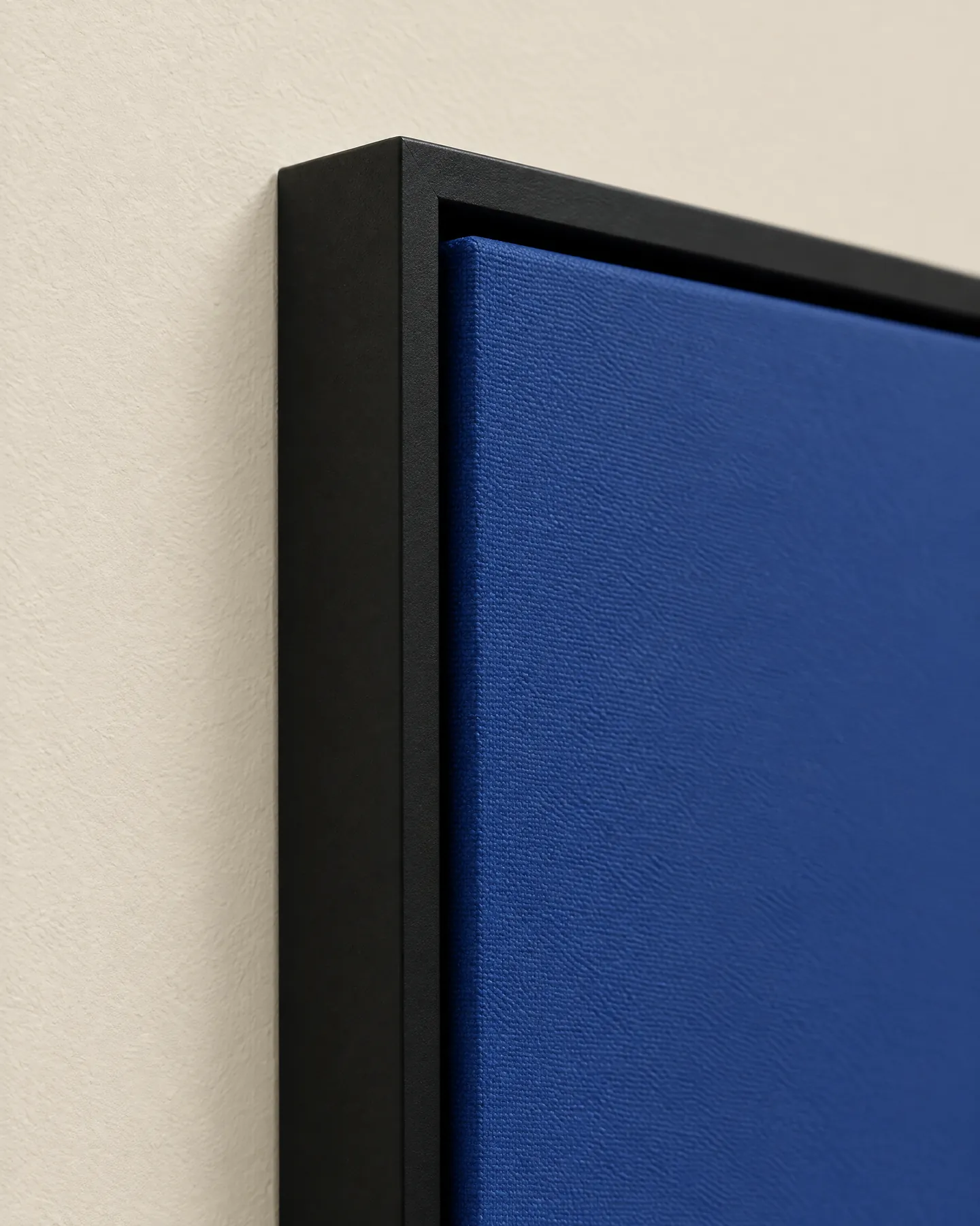 Black floating frame around a blue canvas print, showing the narrow shadow gap